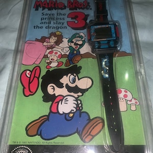 Super Mario Bros. 3 Nintendo Nelsonic Spieluhr in der Originalverpackung. Seltene kardierte Version mit original ( inzwischen leerer) Quarzbatterie auf der Karte