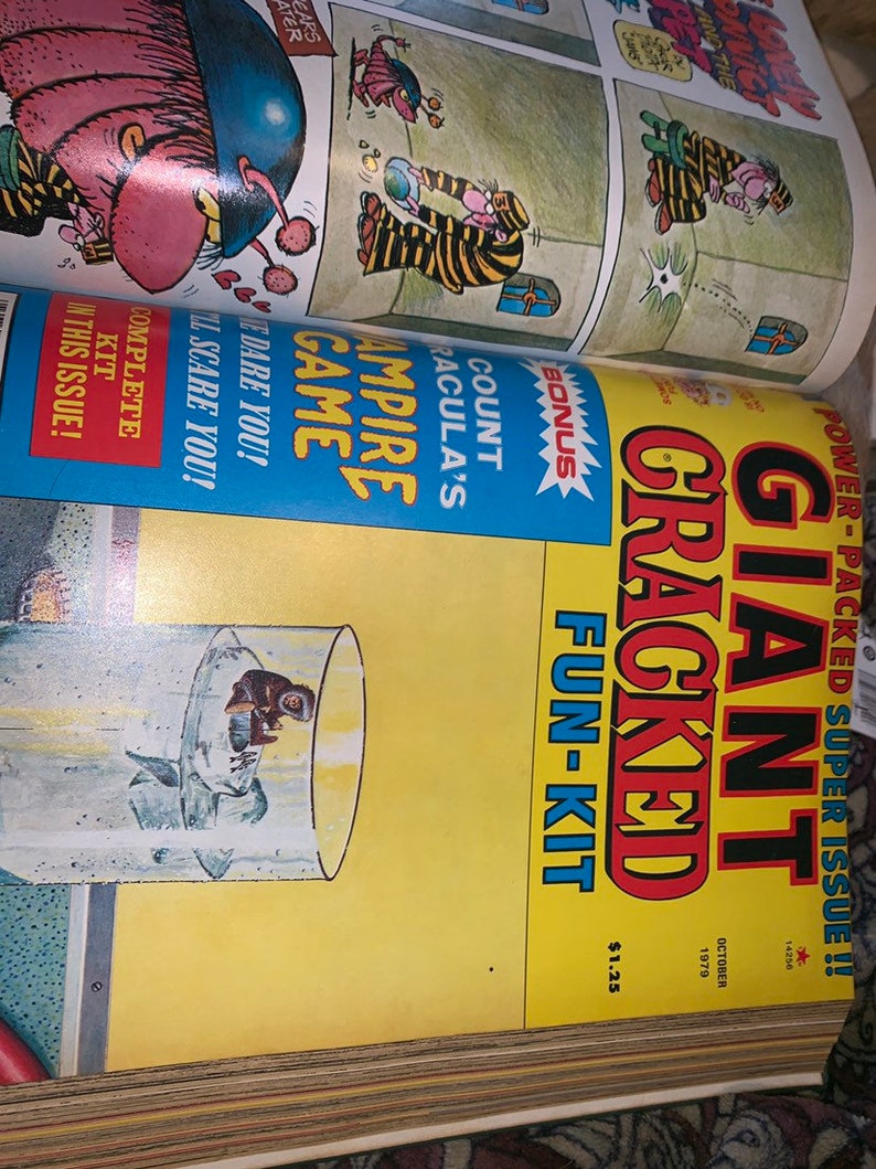 May include: A vintage comic book titled "Giant Cracked Fun-Kit" from October 1979. The cover is yellow with bold red and black text. The comic features cartoon illustrations and the text "Count Dracula's Vampire Game".