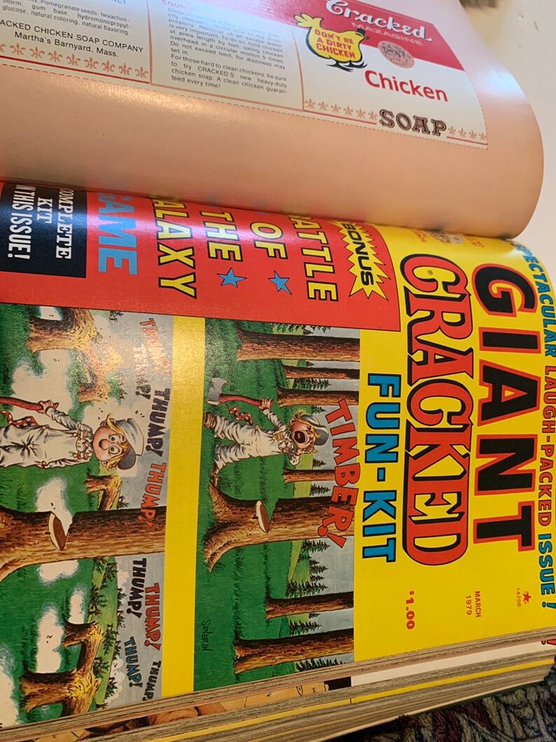 May include: A stack of vintage Cracked magazine issues. The top issue features a cartoon illustration with the words "GIANT CRACKED FUN-KIT" and "TIMBER!" in bold letters. The cover is yellow, red, and green. The magazine also advertises "Chicken Soap".