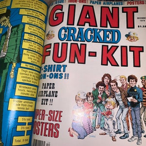 May include: A vintage magazine spread featuring the cover of "GIANT CRACKED FUN-KIT" from December 1979. The cover art includes a group of cartoon characters and the magazine's title in bold, colorful lettering. Inside, there are illustrations and text.