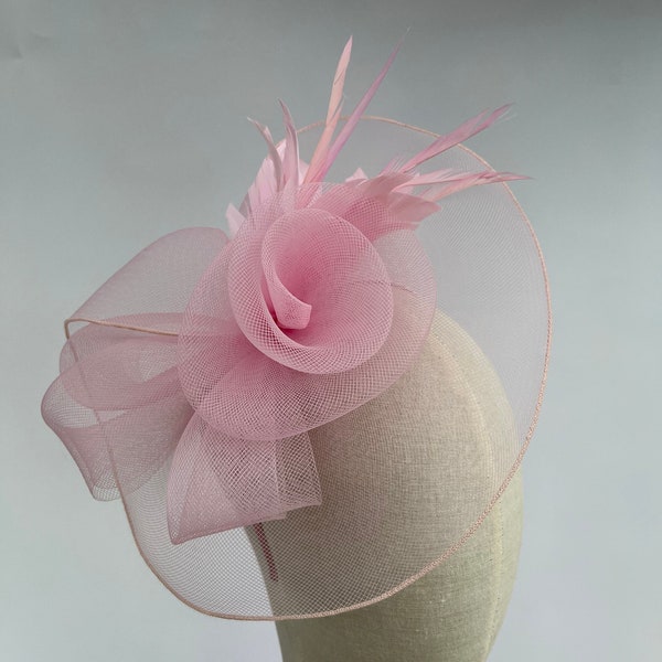 Tocado de malla rosa con doble flor, diadema y pinza con flor de pluma.