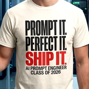 Peut inclure: Un t-shirt à manches courtes de couleur crème avec le texte noir PROMPT IT. PERFECT IT. et le texte rouge SHIP IT. En dessous, le texte noir indique AI PROMPT ENGINEER CLASS OF 2026. Le t-shirt possède une encolure ronde et une coupe standard.