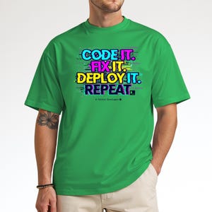 Irish green t-shirt with electric neon cyan and magenta glitch text. High-contrast "Code It Fix It" design for Python developers and computer science students. Edgy hacker aesthetic.