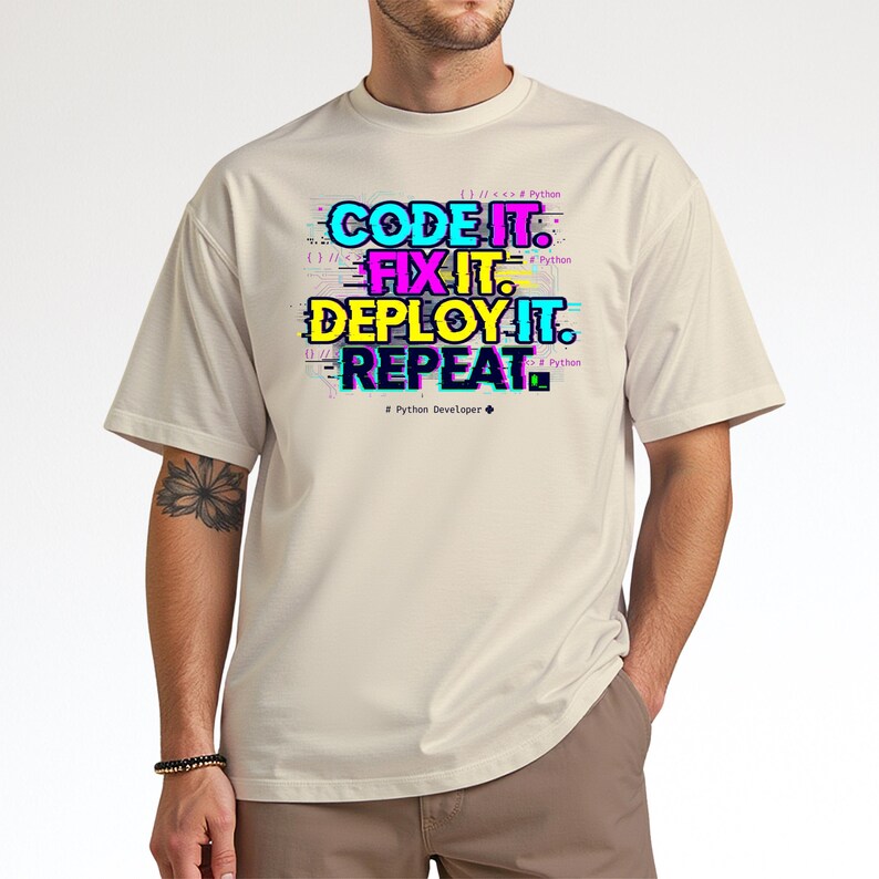 Natural beige tee with a colorful vibrant glitch-style programming quote. "Code Fix Deploy Repeat" graduation gift for Class of 2026 computer science majors.