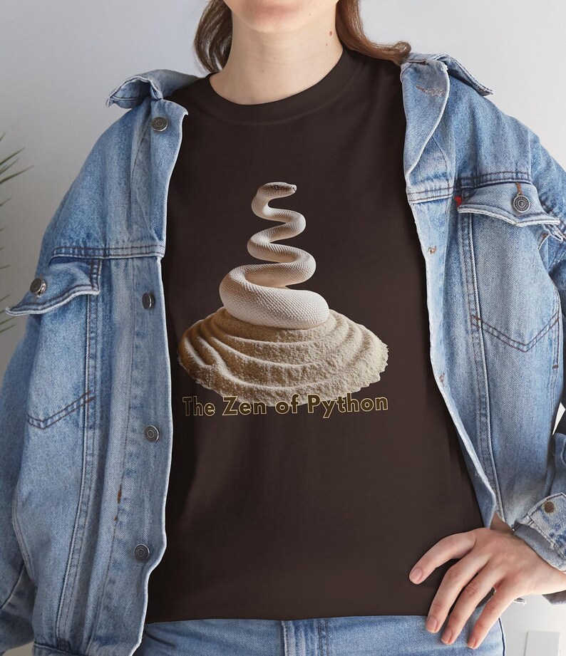 K&ouml;nnte beinhalten: Dunkelbraunes T-Shirt mit einem wei&szlig;en Schlangenmuster, das sich auf einer strukturierten, beigefarbenen Basis windet. Der Text "The Zen of Python" ist in Hellbraun gedruckt. Die Person tr&auml;gt eine Jeansjacke.