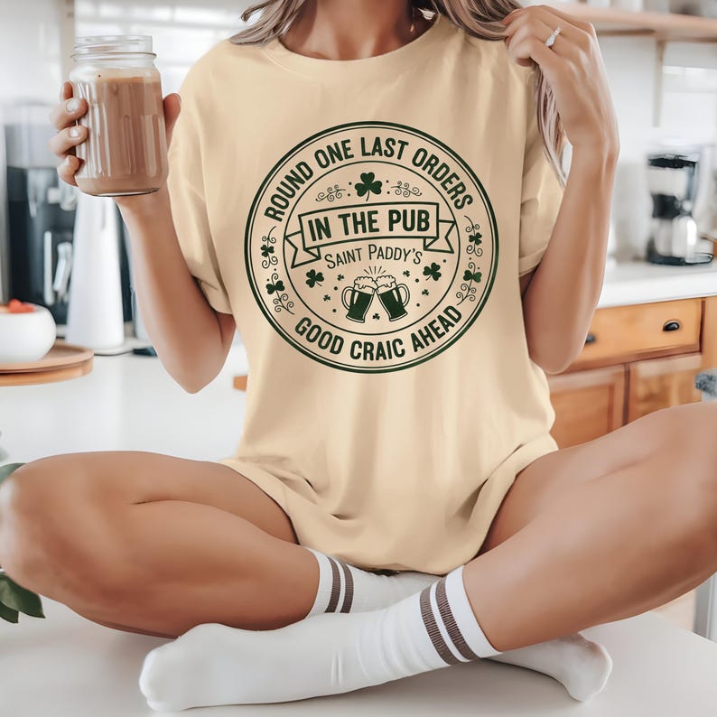 Yellow Haze beige unisex t-shirt with a dark green "Last Orders In The Pub" emblem. The vintage-style beer mug graphic and shamrock details give it a retro, worn-in Irish bar feel, ideal for a casual, understated St. Patrick's Day outfit.