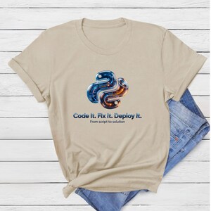 Sand beige t-shirt featuring a futuristic 3D metallic python snake with glowing internal code. Text: "Code it. Fix it. Deploy it." Modern tech gift for 2026 software engineers.