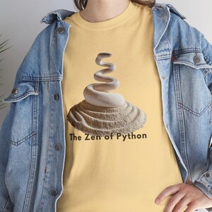 Yellow haze t-shirt featuring a detailed white python snake in a serene Zen sand garden. "The Zen of Python" motto for developers. High-end, sophisticated STEM graphic.