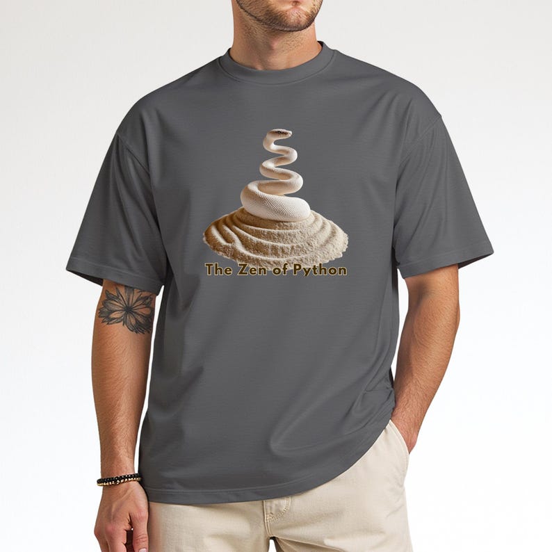Charcoal grey t-shirt with an elegant minimalist print of a white coiled python on a raked sand garden. "The Zen of Python" text below. Aesthetic tech apparel for programmers and computer science grads.