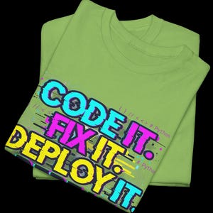 Kiwi green t-shirt with electric neon cyan and magenta glitch text. High-contrast "Code It Fix It" design for Python developers and computer science students. Edgy hacker aesthetic.