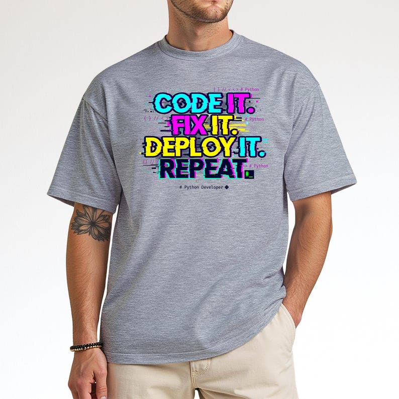 Sport grey t-shirt with a neon glitch typography design: "CODE IT. FIX IT. DEPLOY IT. REPEAT." and "# Python Developer". Gritty, modern streetwear for programmers and engineers.