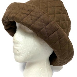 May include: A brown quilted bucket hat. The hat is made of a soft, comfortable fabric and has a wide brim.