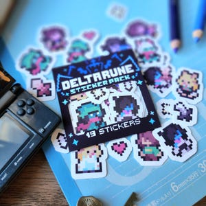 May include: A sticker pack featuring 19 pixel art stickers of characters from the video game Deltarune. The stickers are on a blue background with white stars. The text "Deltarune Sticker Pack" and "19 Stickers" is printed on the sticker sheet.