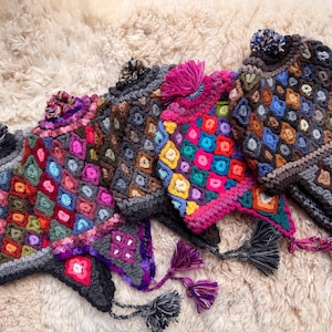 May include: Several brightly coloured, crocheted winter hats with geometric designs. Each hat has a pom-pom and tassel details, with a range of colours including pink, blue, and green. The hats are displayed on a textured, cream-coloured surface.