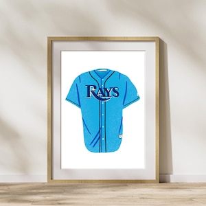 May include: A blue baseball jersey with the word "Rays" in navy blue lettering on the front. The jersey has a white collar and white sleeves with navy blue trim.