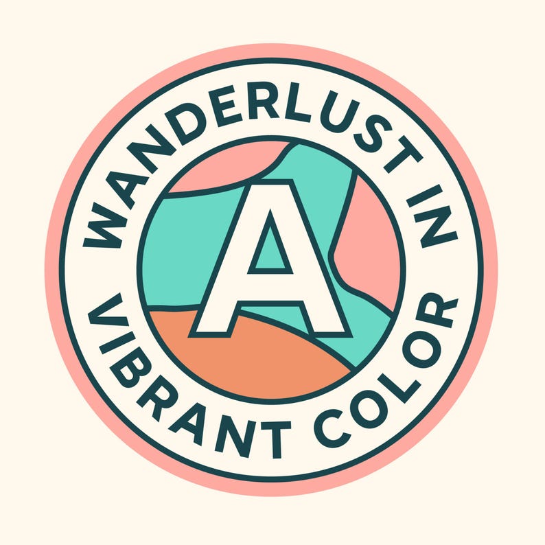 May include: A round sticker with the words "WANDERLUST IN VIBRANT COLOR" in a circular design. The sticker features a large white letter "A" in the center, with a teal, pink, and orange background. The sticker has a light pink border.