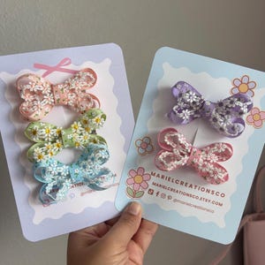 May include: A set of three ceramic mugs with a speckled, matte finish. The mugs are in shades of cream, light gray, and dark gray. Each mug has a simple, minimalist design, perfect for coffee or tea.