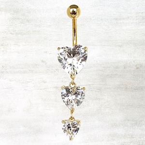 May include: Gold belly button ring with three dangling heart-shaped clear crystal stones.