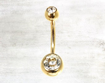 May include: Gold belly button ring with clear crystal stones.