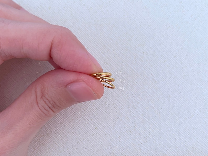 May include: Three gold hoop earrings of different sizes, labeled 16g, 18g, and 20g.