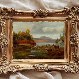 Puede incluir: Una pintura al óleo enmarcada que representa un sereno paisaje otoñal con un lago, árboles y un pequeño grupo de ciervos en primer plano. La pintura está enmarcada en un marco dorado ornamentado.