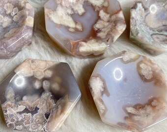 May include: Six agate crystal dishes in various shades of grey and white with a hexagonal shape. The dishes are made of natural stone and have a smooth, polished finish.