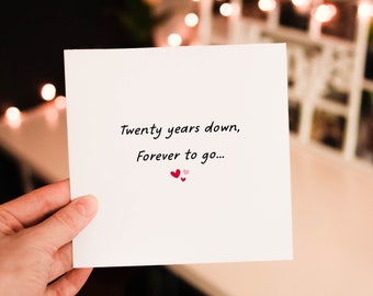 May include: A white card with the text "Twenty years down, Forever to go..." and two small red hearts and one pink heart.