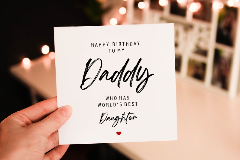 Puede incluir: Una tarjeta blanca con texto negro que dice "Feliz cumplea&ntilde;os a mi pap&aacute; que tiene la mejor hija del mundo" con un peque&ntilde;o coraz&oacute;n rojo en la parte inferior.