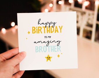 May include: A white card with the text "happy birthday to my amazing brother" in black, yellow, and blue lettering. A yellow star with a smiley face is at the bottom of the card.