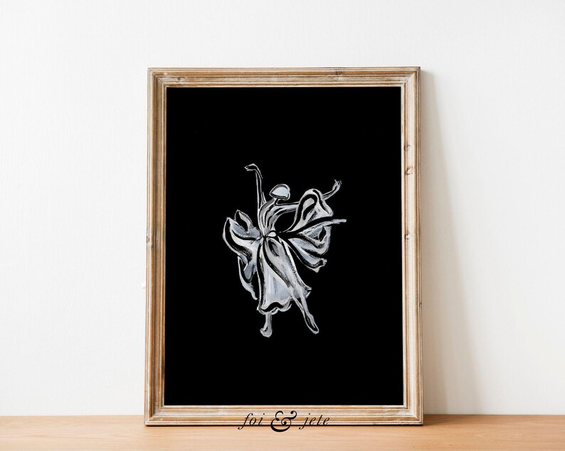 Pode incluir: Uma ilustra&ccedil;&atilde;o em preto e branco de uma bailarina com um vestido fluido, sobre um fundo preto. A imagem est&aacute; emoldurada em uma moldura de madeira clara.