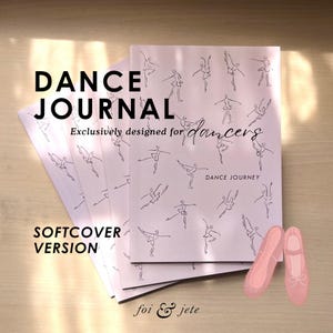 May include: A stack of softcover dance journals with a pale pink cover featuring line drawings of dancers. The text "DANCE JOURNAL" is displayed in large black letters, with "Exclusively designed for dancers" below. A pair of pink ballet shoes is also shown.