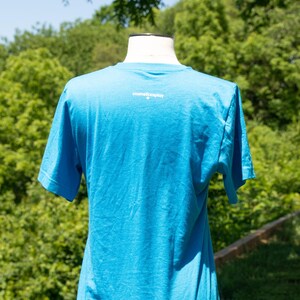 May include: A bright blue t-shirt with the text "cosmiccosplay" printed on the back.