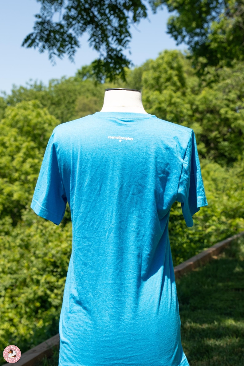 May include: A bright blue t-shirt with the text "cosmiccosplay" printed on the back.