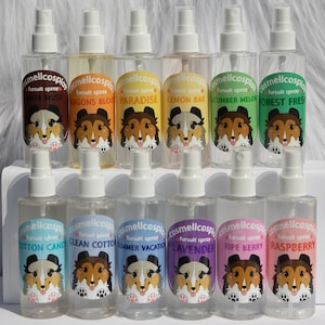 May include: Transparent spray bottles with white atomisers, each labelled with a scent name and a cartoon dog illustration. Scents include Dark Musk, Dragons Blood, Paradise, Lemon Bar, Cucumber Melon, and Forest Fresh.