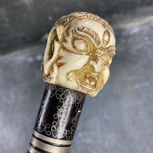 Silver damascened cane with Indian Rakshasa demon head knob in bone, 19th century