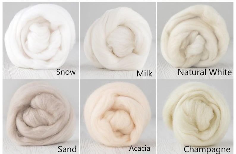 Op de afbeelding: Zes ronde bundels van zachte, vezelige wolvilt, gerangschikt in een raster. De kleuren zijn gelabeld als Snow, Milk, Natural White, Sand, Acacia en Champagne. Elke bundel vertoont een pluizige textuur en een unieke tint wit, cr&egrave;me of beige.