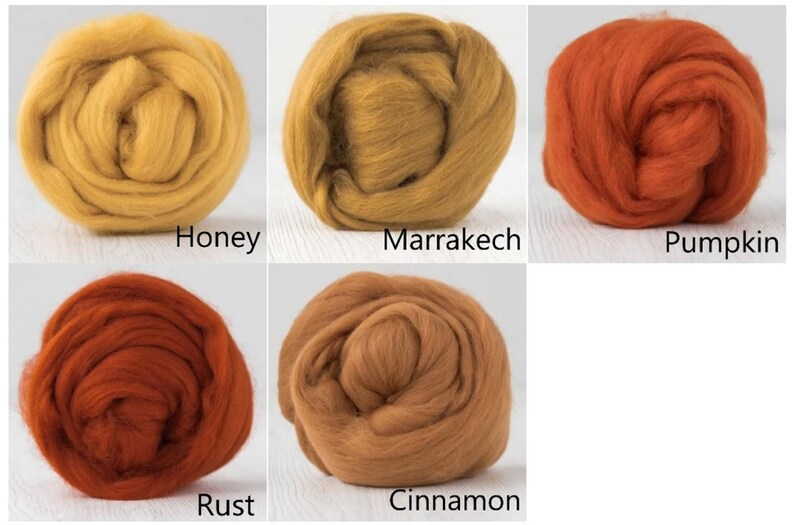 Op de afbeelding: Vijf ronde bundels wolvilt gerangschikt in een raster. De kleuren zijn gelabeld als Honey, een helder geel; Marrakech, een goudbruin; Pumpkin, een levendig oranje; Rust, een diep roodachtig oranje; en Cinnamon, een warm medium bruin.
