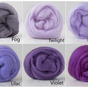 Op de afbeelding: Zes ronde bundels wolvilt gerangschikt in een raster. De kleuren zijn gelabeld als Fog, een grijs; Twilight, een bleek lavendel; Lavender, een lichtpaars; Lilac, een middenpaars; Violet, een dieppaars; en Theatre, een levendig donkerpaars.
