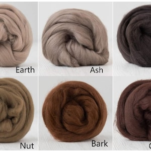 Op de afbeelding: Zes bollen wolvilt gerangschikt in een raster, gelabeld Earth, Ash, Coffee, Nut, Bark en Chocolate. De kleuren vari&euml;ren van lichtbeige en taupe tot verschillende bruintinten, waaronder donkere espresso- en roodbruine tinten.