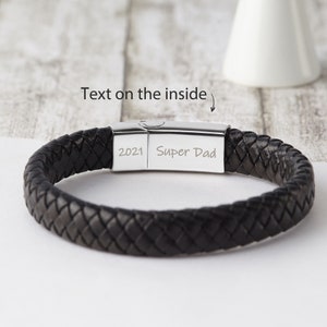May include: Black leather braided bracelet with a silver clasp. The clasp is engraved with the text "2021 Super Dad".