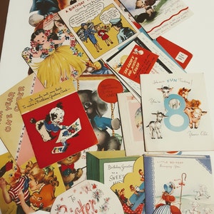 May include: A collection of vintage birthday cards featuring various illustrations and designs. The cards are colorful and feature themes such as animals, children, and travel. Some of the cards have handwritten messages and are in good condition.