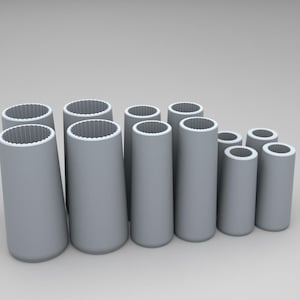 Può includere: Una collezione di dieci oggetti cilindrici grigio chiaro con basi affusolate e bordi interni scanalati a forma di ingranaggio. Gli articoli variano in altezza e larghezza, presentando superfici esterne lisce e opache e centri cavi.