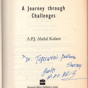 May include: Open book titled "TURNING POINTS" by A.P.J. Abdul Kalam. The book's title is in bold black letters. The page is signed in blue ink, with the words "Dr. Tapeshwini Pradhan" visible. Published by HarperCollins Publishers India.