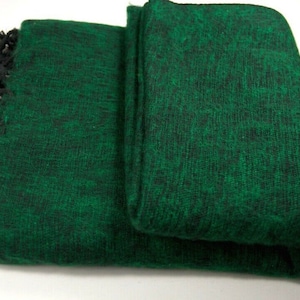 May include: A dark green shawl with black fringe. The shawl is made of a soft, fuzzy material.