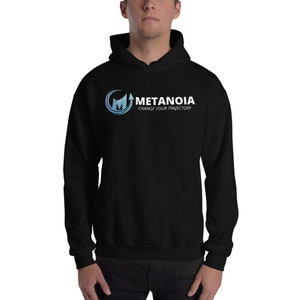Pode incluir: Camisola de capuz preta com um logotipo branco que diz "Metanoia Change Your Trajectory". O logotipo apresenta um "M" estilizado com uma seta apontando para cima.
