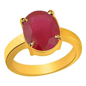 May include: A gold ring with a large, oval-shaped ruby gemstone. The ruby is a deep red color and has a faceted cut.