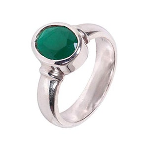 May include: A silver ring with a green oval gemstone set in a bezel setting.
