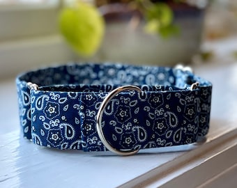 Könnte beinhalten: Ein marineblaues Hundehalsband mit weißem Paisley-Muster. Das Halsband hat einen silbernen Metallring. Das Hundehalsband wird auf einer weißen Oberfläche präsentiert. Für Hunde.