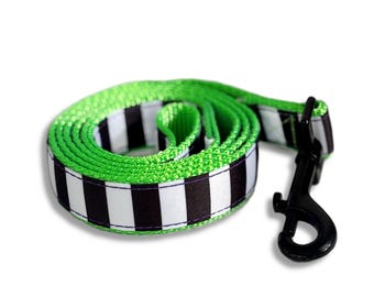 May include: A coiled pet leash featuring a repeating pattern of vertical black and white stripes, accented by bright neon green edges. The leash is equipped with a sturdy black metal swivel snap hook attached to one end for secure fastening.
