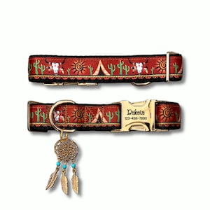 May include: A red pet collar featuring a pattern of cacti, suns, tents, and skulls. The collar includes a gold-toned metal buckle engraved with the name Dakota and the phone number 123-456-7890, plus a dangling dreamcatcher charm with turquoise beads.